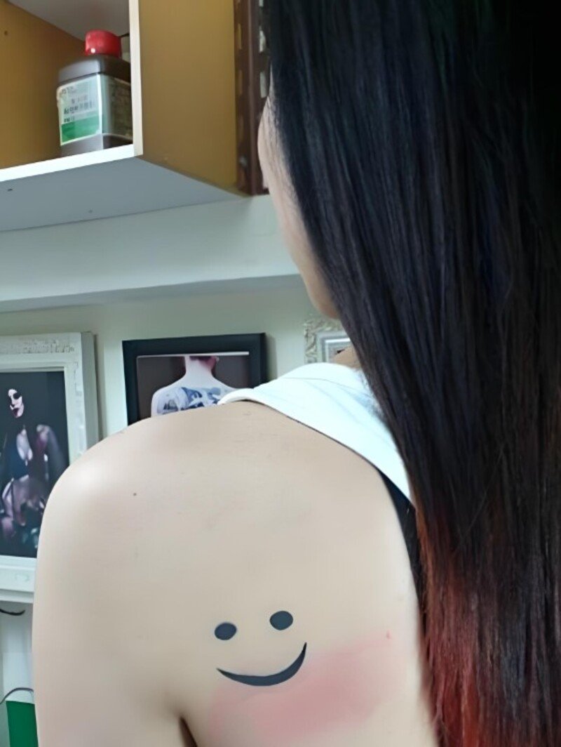 hình xăm mặt cười ở vai cho nữ